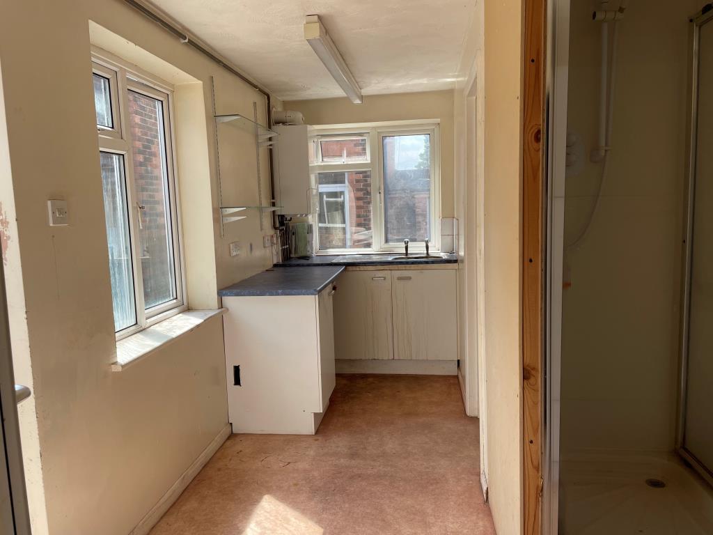 Lot: 139 - RETAIL UNIT AND WORKSHOP WITH GARAGE AND TWO FLATS - Rear kitchen with units and shoer cubicle